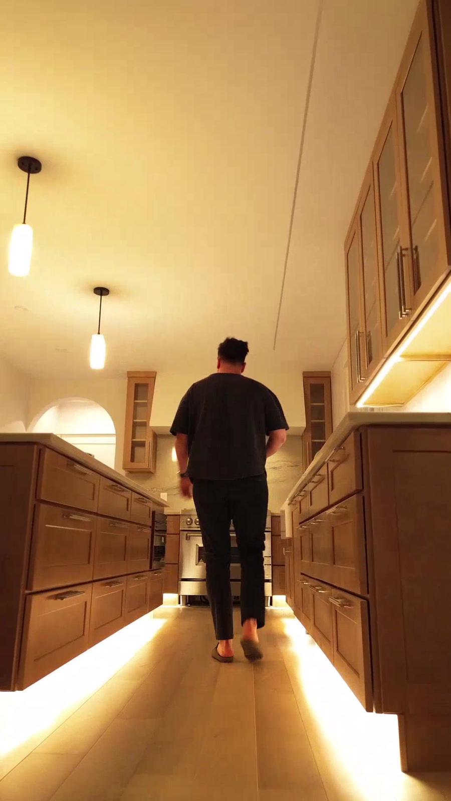 Figure walking through Casa DOS kitchen at night with under-cabinet glow