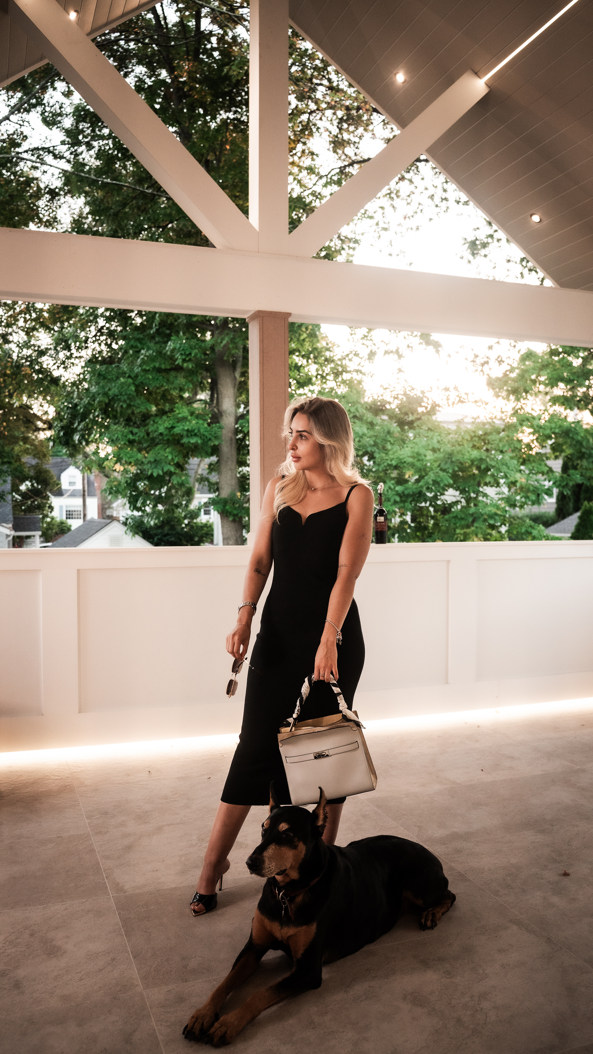 Alejandra on the balcony of a finished More Life home at dusk, in color.