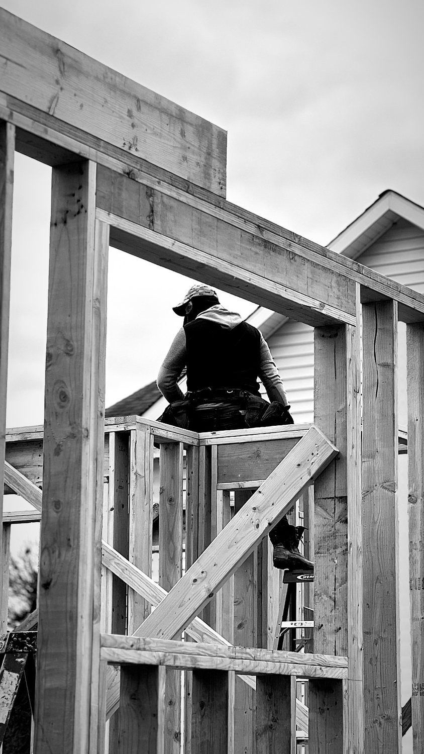 A builder at work on a More Life home, black and white.