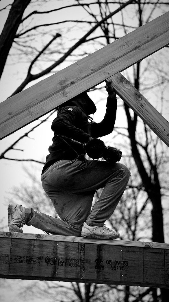 A builder at work on a More Life home, black and white.