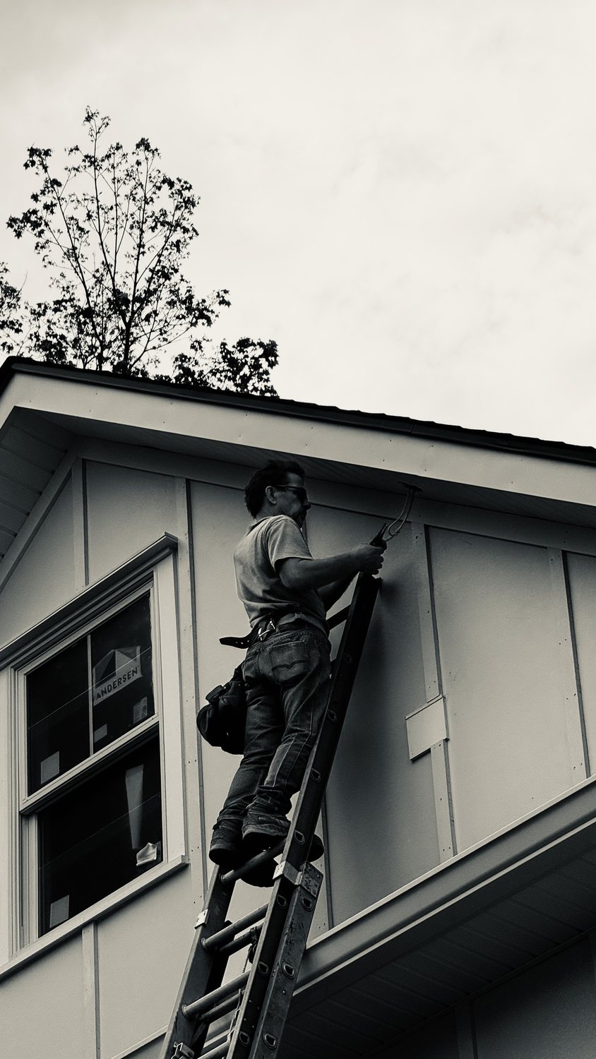 A builder at work on a More Life home, black and white.