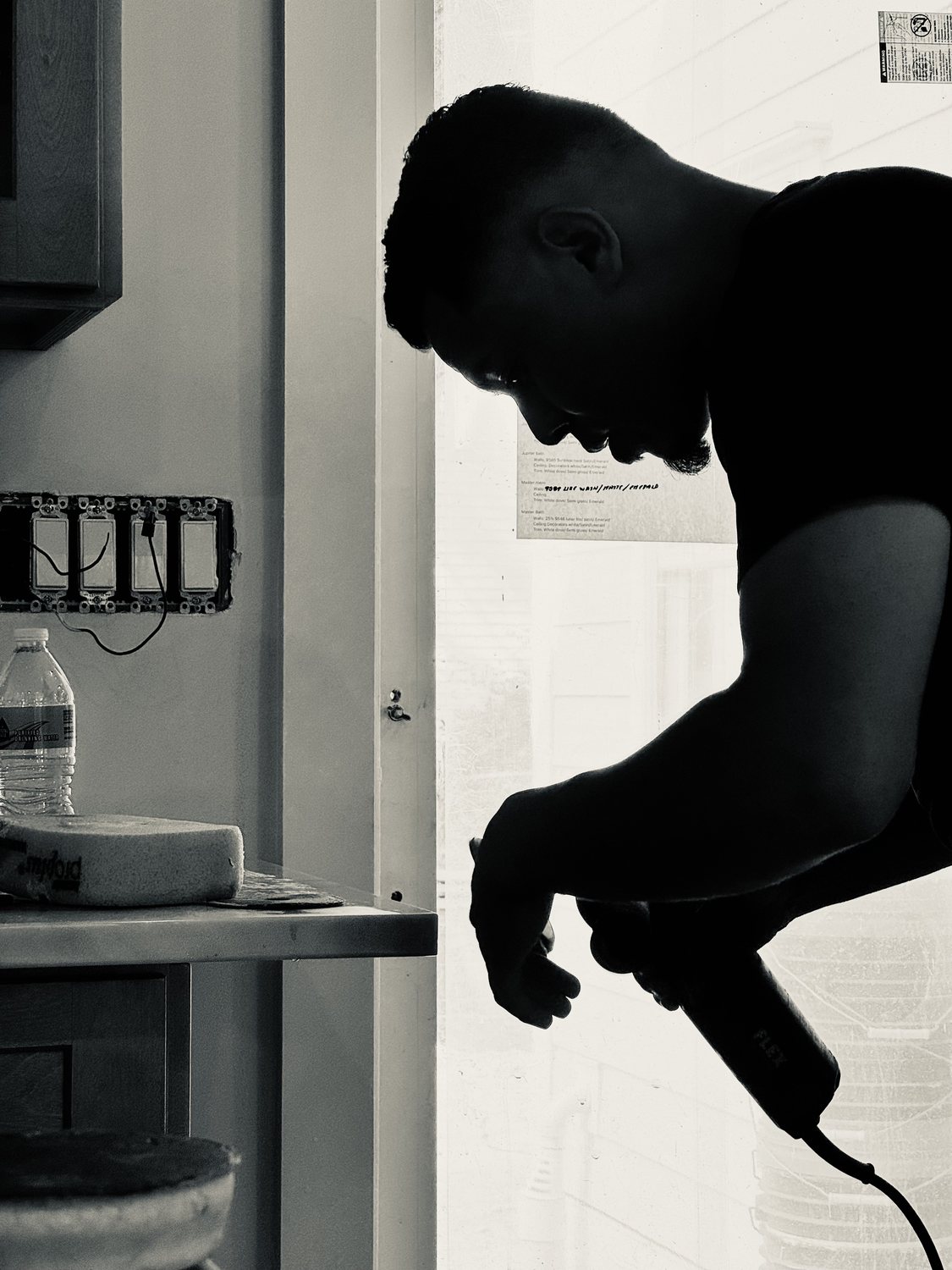 A builder at work on a More Life home, black and white.