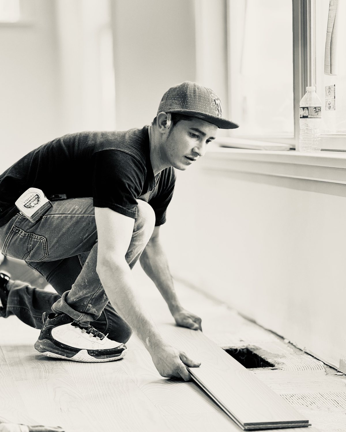A builder at work on a More Life home, black and white.